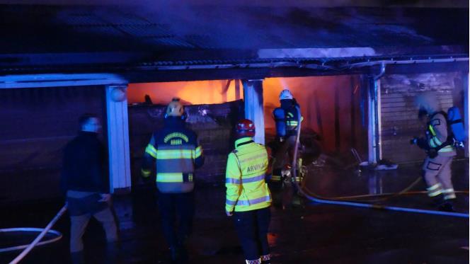 Fullt utvecklad brand i garagelnga  kraftig rkutveckling frn flera garage